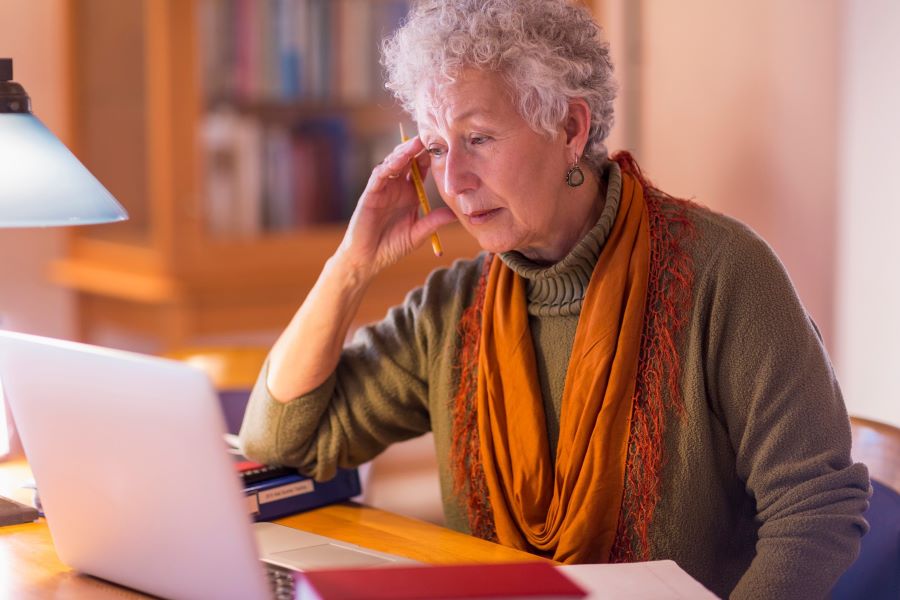 A woman stares worriedly at her computer.